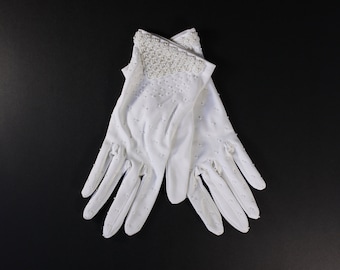 May include: A pair of white gloves with a beaded detail on the back of the hand.