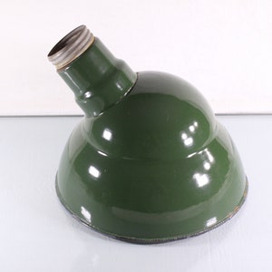 May include: A green metal lampshade with a rounded shape and a standard light bulb socket.