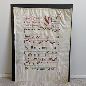 May include: A vintage sheet of music with handwritten notes and lyrics in brown ink on a cream-colored background. The text reads "im propio finctorů, gìn cơi vhus mis pötificis. Introitus Ca tuit ci do mnus to ſtame ntu pa cis et paincipe fe cit cum vt fit".