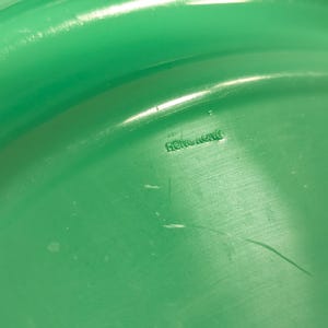 May include: Close-up of a green plastic disc with the words "Hong Kong" printed on the underside.