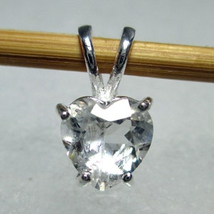 May include: A silver heart-shaped pendant with a clear crystal stone.