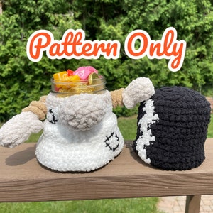 Peut inclure: Une poupée au crochet blanche et beige avec une tête en bocal remplie de bonbons et un chapeau au crochet noir et blanc. La poupée a des bras et est décorée de coutures noires. Le texte "Pattern Only" est affiché en orange.
