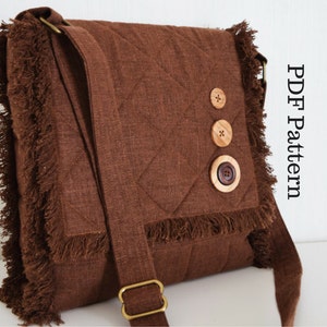 Puede incluir: Un bolso bandolera acolchado marrón con flecos y botones de madera. El bolso tiene una correa larga ajustable y un cierre de solapa. Patrón PDF.