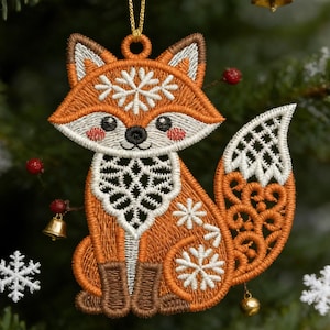 May include: Embroidered orange fox Christmas ornament with white snowflake details. The fox has a white face, ears, and tail, with a gold hanging loop. The ornament is decorated with snowflakes and a gold bell.