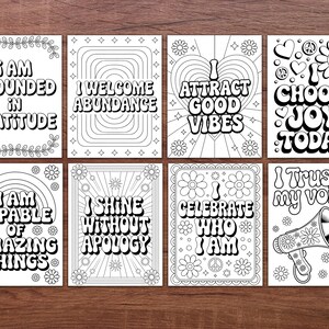 May include: A set of eight black and white inspirational quote cards. Each card features a unique design with phrases like "I AM GROUNDED IN GRATITUDE" and "I CHOOSE JOY TODAY." The cards are decorated with floral and retro-style elements.