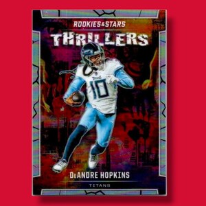 May include: A trading card featuring DeAndre Hopkins of the Tennessee Titans in a football uniform. The card is part of the "Rookies & Stars Thrillers" series. The background has a distressed, colorful design.