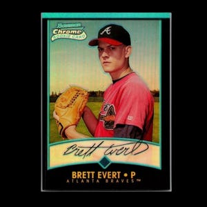 May include: A baseball card featuring Brett Evert of the Atlanta Braves. The card has a teal border and the words "Bowman Chrome Rookie Card" at the top. Evert is wearing a red and black baseball uniform and a black cap with a red brim.