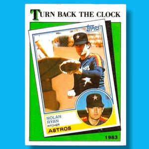 May include: A vintage baseball card featuring Nolan Ryan, pitcher for the Astros, in a blue, orange, and white uniform. The card includes a smaller portrait of Ryan and the text "Turn Back the Clock" and "1983".