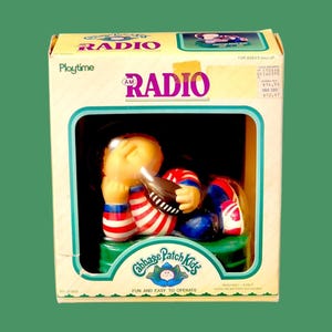 Puede incluir: Una radio AM Cabbage Patch Kids vintage en su caja original. La radio presenta una figura de Cabbage Patch Kid con ropa roja, blanca y azul. La caja dice "Playtime" y "Fun and Easy to Operate."