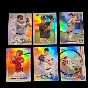 Könnte beinhalten: Sechs Baseball-Sammelkarten mit holografischen Oberflächen. Die Karten zeigen Spieler in Aktion, mit Texten wie "40-Man Futures", "Dawn of Glory" und "Bowman Scout Top 100". Die Spieler sind in ihren Teamuniformen abgebildet.