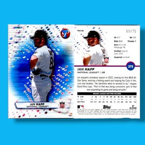 May include: A baseball card featuring Ian Happ of the National League. The card has a blue and white design with a photo of the player in a baseball uniform. The card includes player stats and biographical information.