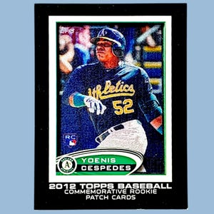 May include: A baseball card featuring Yoenis Cespedes in an Oakland Athletics uniform. The card has a black border with text at the bottom that reads "2012 Topps Baseball Commemorative Rookie Patch Cards."