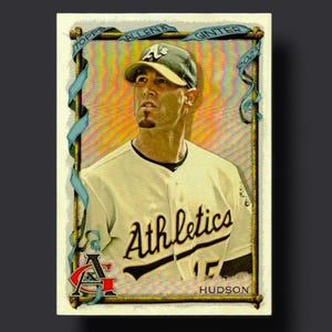 May include: A baseball trading card featuring a player in an Athletics uniform. The card has a gold border and includes the text "Topps Allen & Ginter 2023" at the top. The player's name, Hudson, is at the bottom.