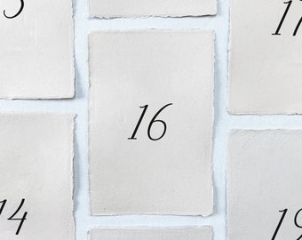 Printed wedding table numbers on handmade paper for a modern and minimalist wedding reception or rehearsal dinner