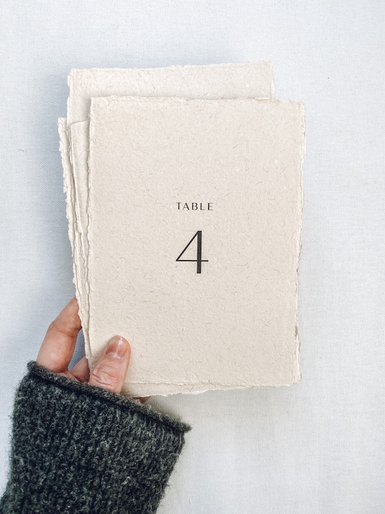 May include: A beige table number card with the text "TABLE 4" printed in black.