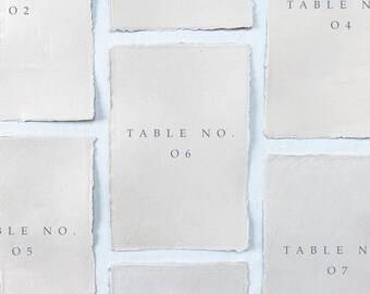 Printed wedding table numbers on handmade paper for a modern and minimalist wedding reception or rehearsal dinner