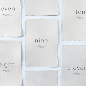 The Emily Collection: Printed wedding table numbers on handmade paper for a modern and minimalist wedding reception or rehearsal dinner