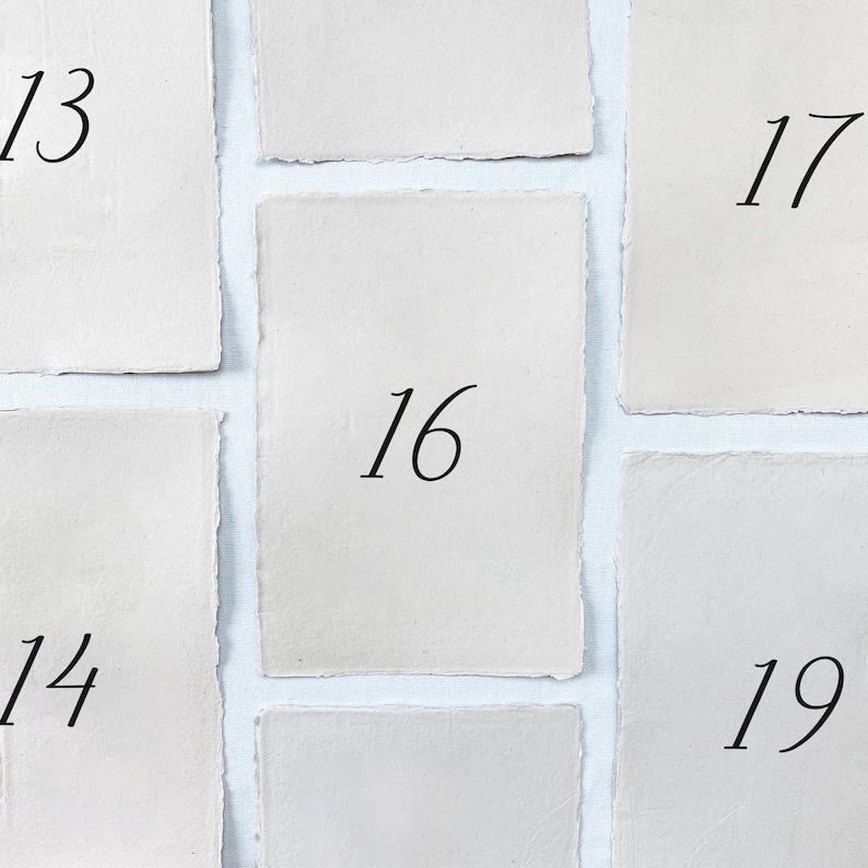 May include: A close-up of nine white paper cards with numbers 13, 14, 16, 17, and 19 written on them.