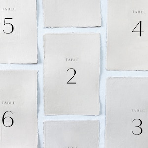 Printed wedding table numbers on handmade paper for a modern and minimalist wedding reception or rehearsal dinner