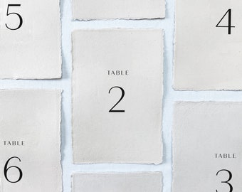 Printed wedding table numbers on handmade paper for a modern and minimalist wedding reception or rehearsal dinner