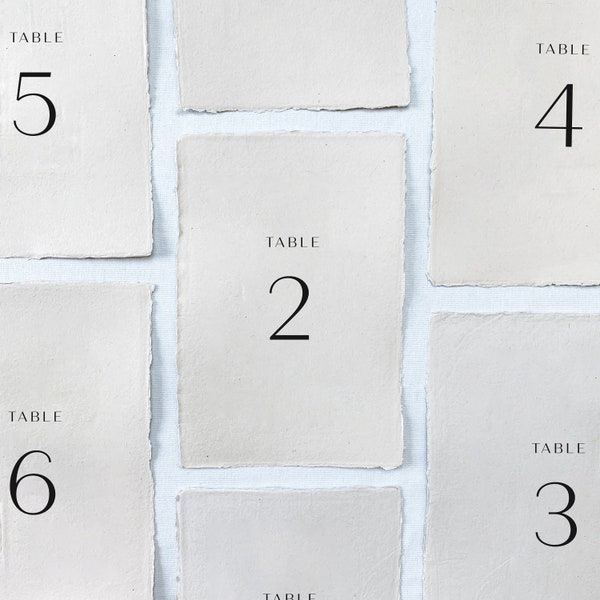 Printed wedding table numbers on handmade paper for a modern and minimalist wedding reception or rehearsal dinner