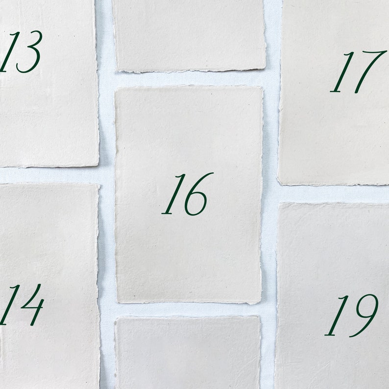 May include: Nine white paper cards with numbers 13, 14, 16, 17, 19 written in green ink on each card.