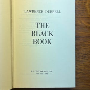 Puede incluir: P&aacute;gina de t&iacute;tulo del libro "The Black Book" de Lawrence Durrell. El t&iacute;tulo est&aacute; en letras grandes y en negrita. Tambi&eacute;n se puede ver la editorial, E. P. Dutton & Co., Inc., y el a&ntilde;o 1960.