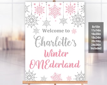 May include: A white sign with pink and silver glitter text that says "Welcome to Charlotte's Winter Wonderland". The sign is decorated with silver glitter snowflakes and pink snowflakes. The sign is available in sizes 8x10in, 11x14in, 16x20in, 18x24in, 20x30in, 24x36in.