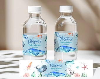 May include: Two clear plastic water bottles with blue and white labels featuring a watercolor illustration of sea creatures, including a whale, a narwhal, and a starfish. The labels also include the text "Christina's Baby Shower 5.20.20xx".