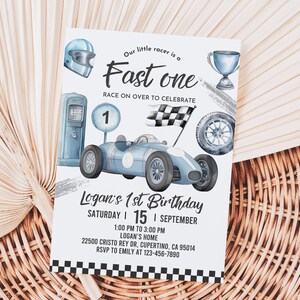 May include: A blue and white birthday invitation with a cartoon race car, checkered flag, and a gas pump. The text reads "Our little racer is a Fast one Race on over to celebrate Logan's 1st Birthday Saturday | 15 | September 1:00 PM to 3:00 PM Logan's Home 22500 Cristo Rey Dr, Cupertino, CA 95014 RSVP to Emily at 123-456-7890"