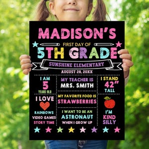 May include: A black chalkboard-style sign with colourful text reading Madison's First Day of 5th Grade at Sunshine Elementary. It includes sections for age 5, teacher Mrs. Smith, height 106.68 cm, favourite food strawberries, and future goals.