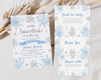 Può includere: Un invito a una festa di benvenuto per un bambino con un fiocco di neve blu e argento, un nastro blu e il testo "Un piccolo fiocco di neve è in arrivo". L'invito include la data, l'ora, il luogo e le informazioni RSVP. Ci sono anche tre biglietti con il testo "Libri per il bambino", "Grazie" e "Lotteria pannolini".