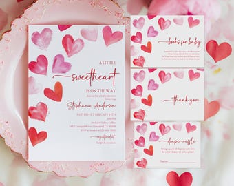 May include: A baby shower invitation and accompanying cards with a watercolor heart theme. The invitation reads "A Little Sweetheart Is On The Way." Cards include "Books for Baby," "Thank You," and "Diaper Raffle." The color palette is red and pink.