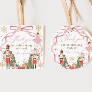 Puede incluir: Dos etiquetas de regalo con temática de Cascanueces. Una es cuadrada, la otra redonda. Ambas tienen una cinta rosa, el texto "Thank you for celebrating with us!" e ilustraciones de un Cascanueces, una bailarina y un ratón.