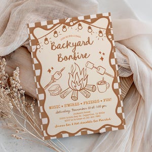 May include: A rectangular invitation card with a brown and cream checkered border. The text reads Join us for a fall Backyard Bonfire, Music, S'mores, Friends, Fun, Saturday, November 10 at 5:00 pm, Jackson's house, 22500 Cristo Rey Dr, Cupertino, CA 95014, RSVP to Kristen at 123-456-7890, S'mores Bar & Hot chocolate Bar Provided. Illustrations include string lights, a campfire, marshmallows on sticks, and a mug.