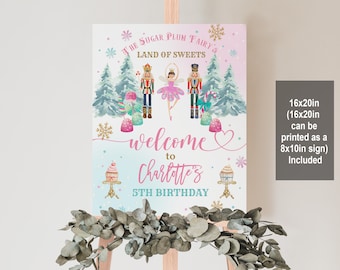 May include: A pink and blue welcome sign for a 5th birthday party with a Nutcracker and Sugar Plum Fairy theme. The sign says "The Sugar Plum Fairy's Land of Sweets" and "Welcome to Charlotte's 5th Birthday".