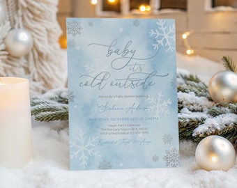 Może przedstawiać: Jasnoniebieskie zaproszenie na baby shower z motywem płatków śniegu i napisem "baby it's cold outside". Zaproszenie zawiera szczegóły wydarzenia, takie jak data, godzina i miejsce.