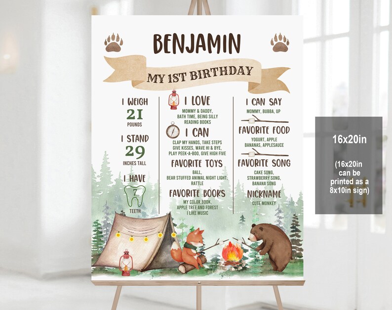 May include: A brown and green illustrated poster with a woodland theme. The poster is for a child's first birthday and includes the child's name, Benjamin, and details about their first year, such as their weight, height, favourite foods, and songs. The poster features a campfire, a tent, a fox, and a bear.