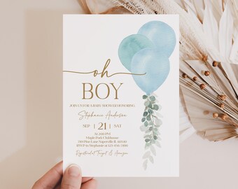 May include: A baby shower invitation with the words "oh BOY" in gold script. The invitation features watercolor balloons in shades of blue and green, with greenery accents. The invitation includes the name "Stephanie Anderson" and event details.