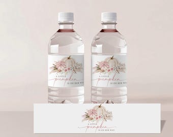 Puede incluir: Dos botellas de agua transparentes con etiquetas que dicen "A little pumpkin is on her way". Las etiquetas presentan una ilustración de acuarela de una calabaza con flores rosas y blancas.