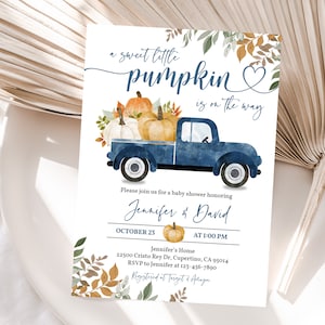 Pu&ograve; includere: Un camioncino blu con una cassone pieno di zucche e foglie autunnali. Il camioncino &egrave; su uno sfondo bianco con il testo "a sweet little pumpkin is on the way".