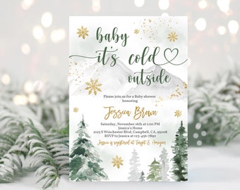 May include: A baby shower invitation with a winter theme. The invitation features a watercolour illustration of a snowy mountain range with a gold heart and snowflakes. The text reads "baby it's cold outside" and includes details for the shower, including the date, time, location, and RSVP information. The invitation also mentions that the guest of honour is registered at Target and Amazon.