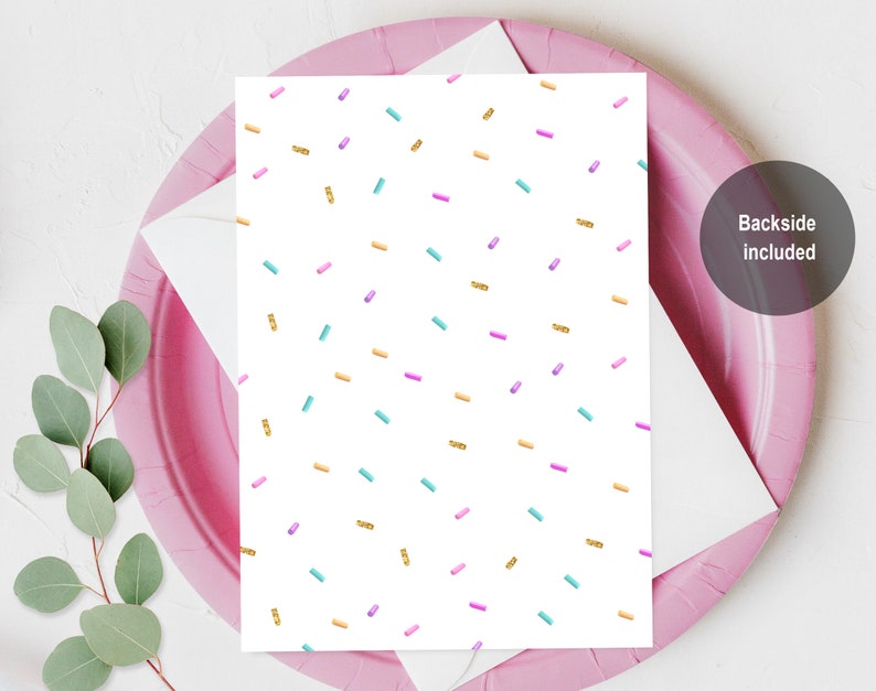 May include: A white card with a repeating pattern of gold, pink, and blue sprinkles. The back of the card is included.