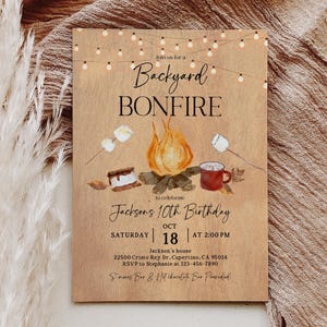 Puede incluir: Una invitaci&oacute;n r&uacute;stica para una fogata en el patio trasero, con una ilustraci&oacute;n en acuarela de una fogata, malvaviscos y una taza. El texto dice "Backyard Bonfire" y anuncia el d&eacute;cimo cumplea&ntilde;os de Jackson el 18 de octubre a las 2:00 PM.