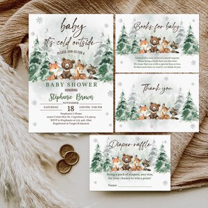 May include: A set of four baby shower invitations with a winter woodland theme. The invitations feature a watercolour illustration of a bear, fox, deer, and raccoon in a snowy forest. The text on the invitations reads "baby it's cold outside" and "Books for baby".