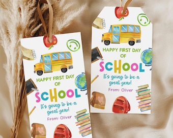 May include: Two rectangular white gift tags with brown ribbon loops, featuring watercolor illustrations of a yellow school bus, red apple, globe, books, and backpack. The text reads: Happy First Day of School, It's going to be a great year!, From: Oliver.