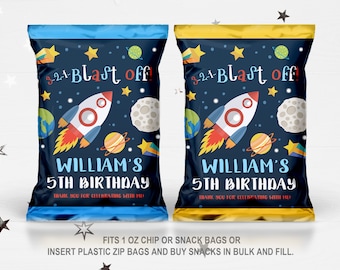 May include: Blue and gold party favour bags with a space theme. The bags feature a rocket, planets, stars, and the moon. The text on the bags reads "3-2-1- Blast off! William's 5th Birthday. Thank you for celebrating with me."