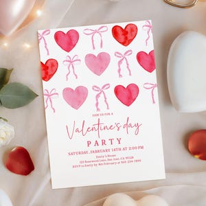 Puede incluir: Una invitaci&oacute;n a una fiesta de San Valent&iacute;n con corazones y lazos de acuarela en tonos rosa y rojo. La invitaci&oacute;n incluye el texto "Join us for a Valentine's Day Party" con la fecha, hora y detalles del lugar.