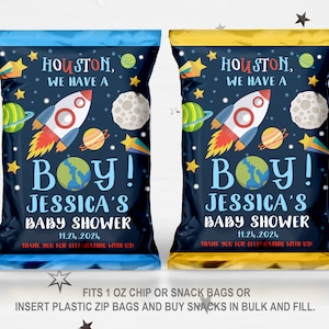 May include: Two blue and gold chip bags with a space-themed design. The bags feature a rocket, planets, and stars. The text on the bags reads "Houston, we have a boy! Jessica's Baby Shower 11.24.2024 Thank you for celebrating with us!"