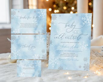 May include: A set of baby shower stationery with a winter theme. The invitation reads "Baby it's cold outside" with snowflake accents. Additional cards include "books for baby", "thank you", and a diaper raffle card. The background is a light blue watercolor.